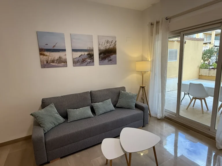 Salón amplio y luminoso con sofá, TV de pantalla plana y acceso directo a la terraza del apartamento turístico en Denia, Costa blanca Salón amplio y luminoso con sofá, TV de pantalla plana y acceso directo a la terraza del apartamento turístico en Denia